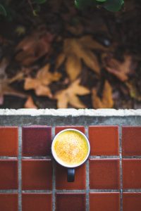 Turmeric latte surrounded by leaves