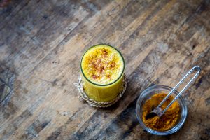 Turmeric latte beside bowls of spices