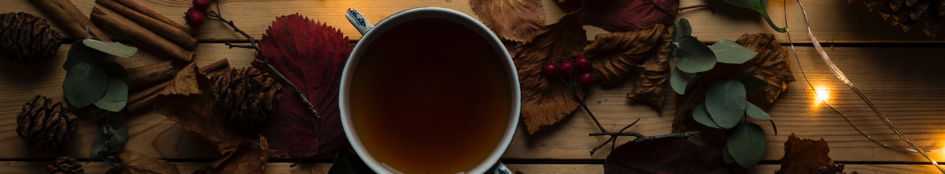 Photo of Chai Tea sitting on a beautiful wooden board covered in leaves an decore