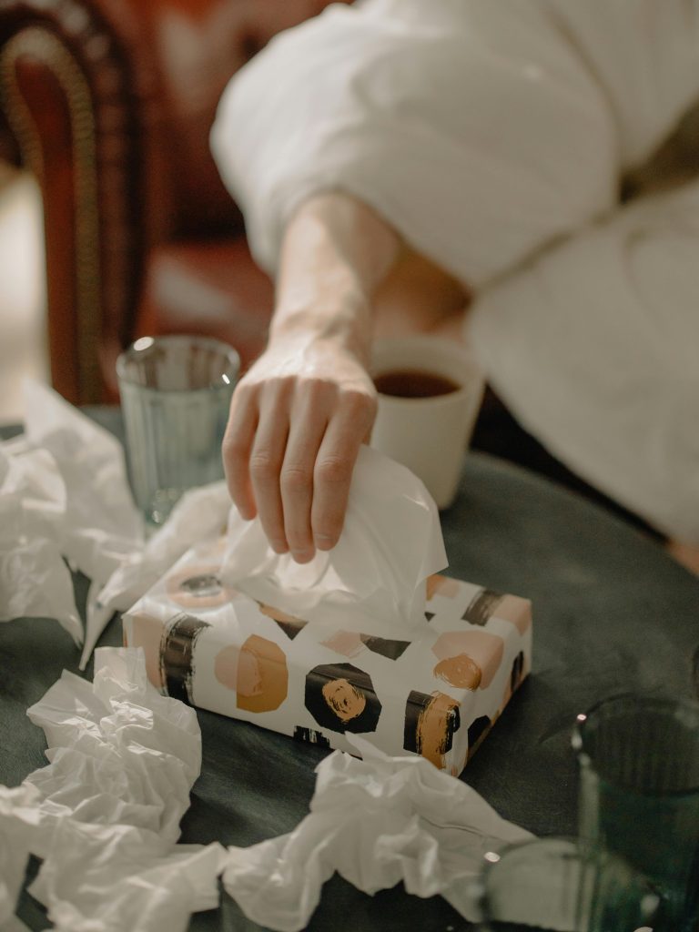 a woman reaching for Kleenex because of Acupuncture and Seasonal Allergies 