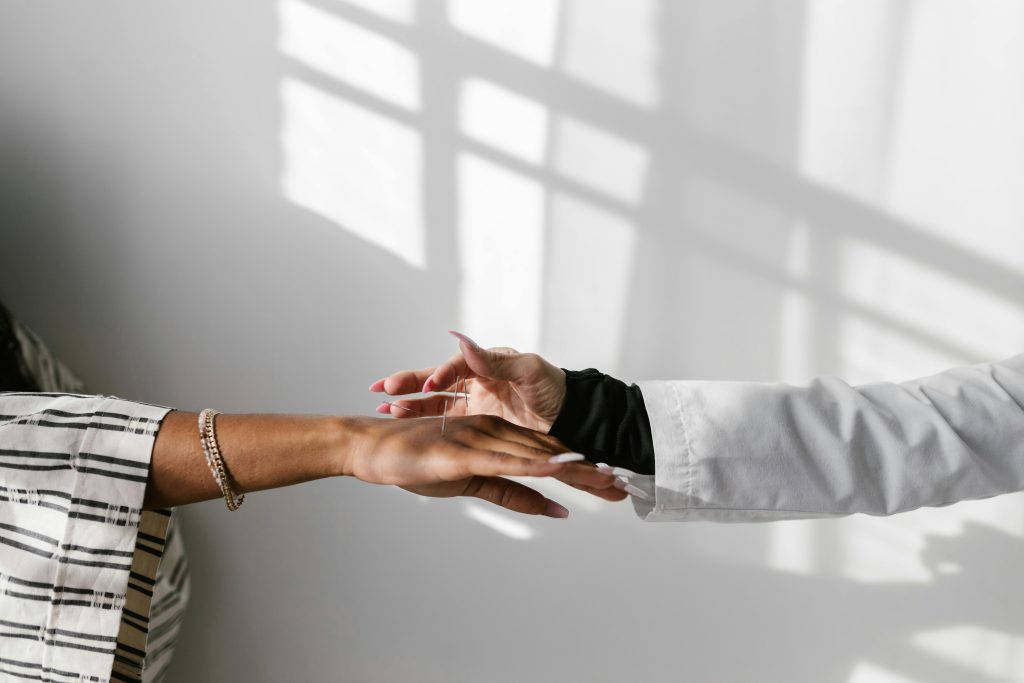 a woman holding out her arm to her acupuncturist- the power of a holistic team