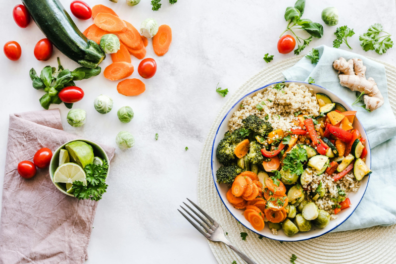 Colorful bowl of vegetables and grains on table, highlighting healthy eating for fertility planning support.