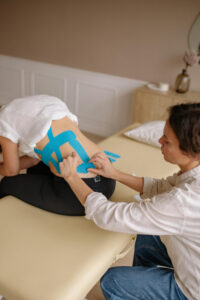 Pregnant person sitting and holding belly, possibly experiencing lower back and pubic symphysis pain in pregnancy.