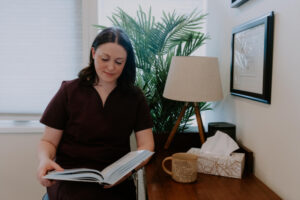 Acupuncturist reviewing patient notes in clinic office while creating personalized treatment plans for estrogen dominance.