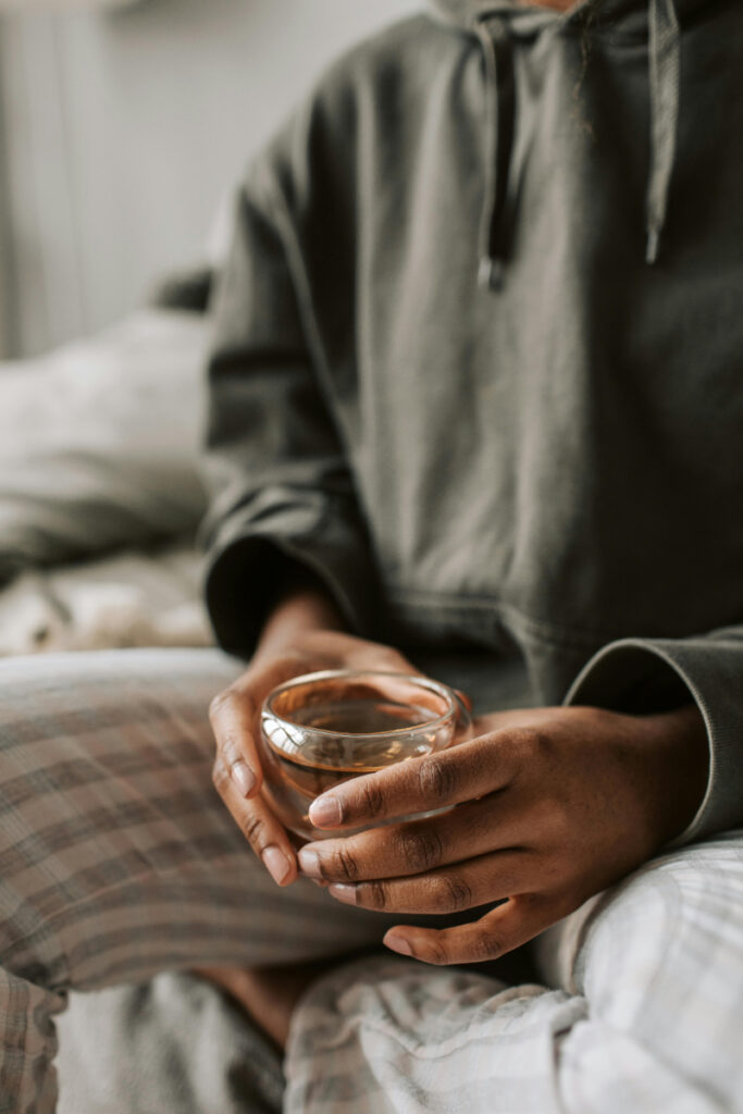 Woman holding warm tea, reflecting on premature ovarian insufficiency symptoms and gentle healing support at home