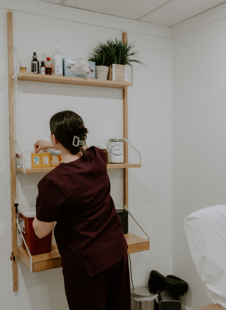 National Infertility Awareness Month acupuncture clinic setting with practitioner preparing treatment space and supplies