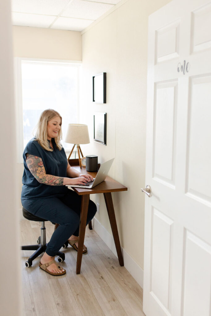 Woman working at a desk during PCOS Awareness Month, focusing on health and wellness education.