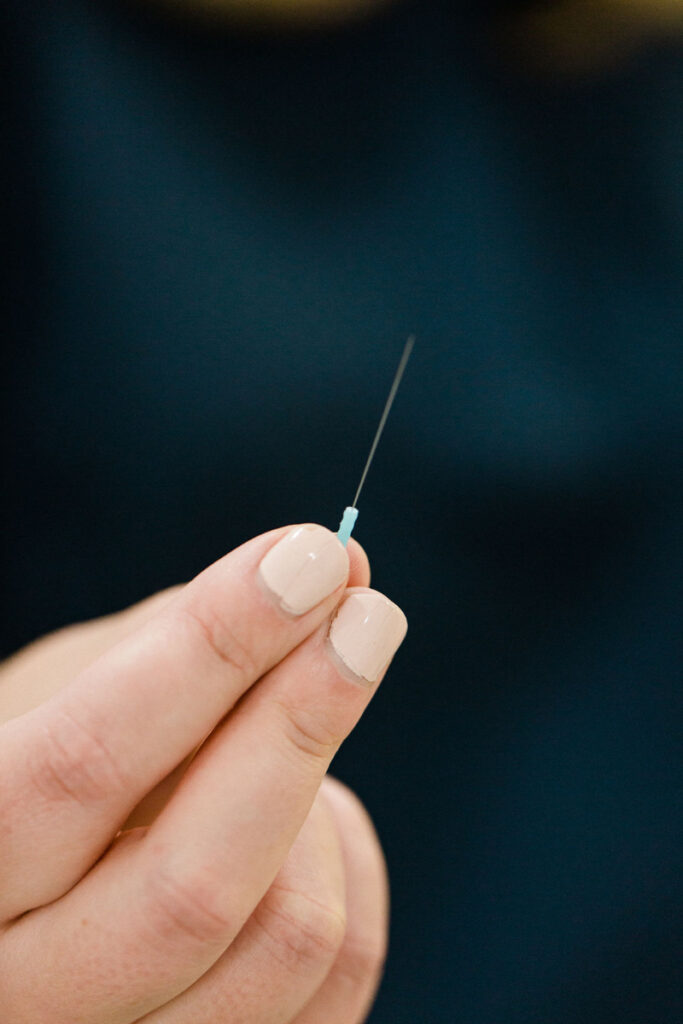 acupuncturist holding acupuncture needle in a close up 